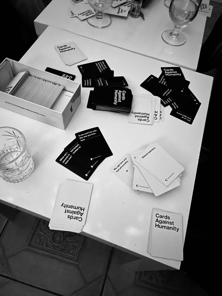 the table is covered with cards and wine glasses