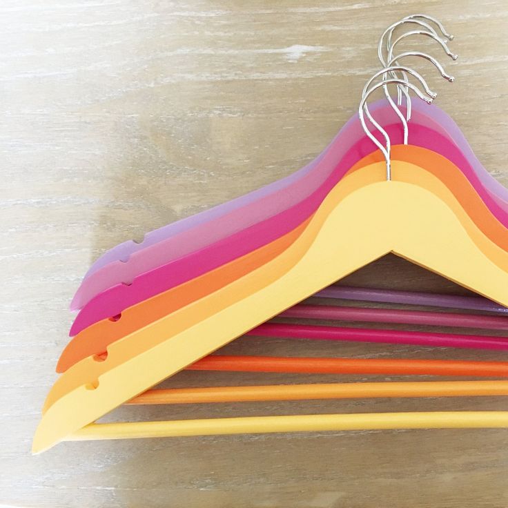 a wooden hanger with several different colored strips hanging from it's sides on a table