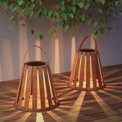 two wooden lanterns sitting on top of a wooden floor