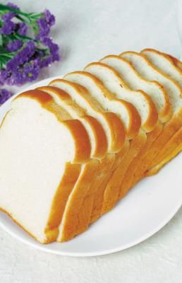 slices of bread on a white plate next to purple flowers