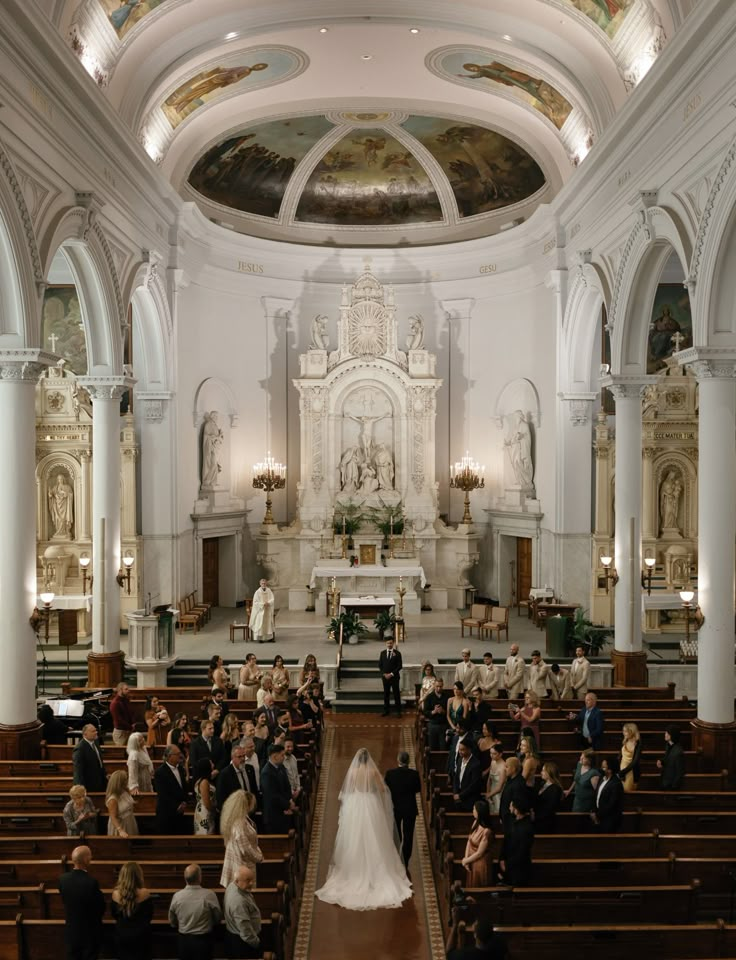 a bride and groom walking down the aisle at their wedding ceremony in an old church