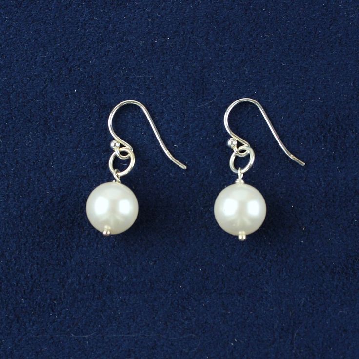 "CLASSIC PEARL Drop Earrings by BorkasJewels These white precious pearl earrings are as their name implies \"A Classic\".  The shiny white Swarovski Pearls are suspended from a sterling silver round ring that is attached to a sterling silver set of ear wires.  This is truly a soft elegant look.  The Classic Pearl Collection includes Necklace, Bracelet and Earrings (short or long). INTIMATE DETAILS: *weigh in at 2 grams *earrings are 1 1/4\" long *Swarovski Pearls are white and 10mm *sterling sil Pearl Collection, Round Rings, Swarovski Pearls, Pearl Drop Earrings, Pearl Drop, Necklace Bracelet, Classic White, Sterling Silber, Ear Wires