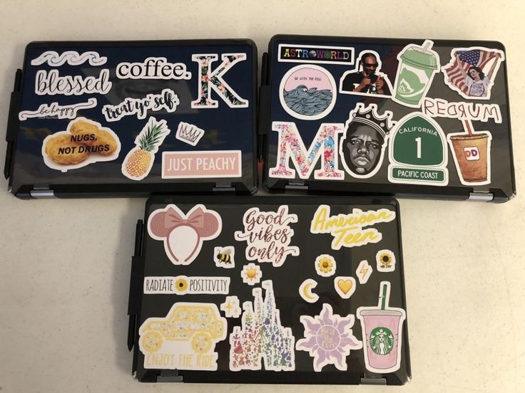 three laptops with various stickers on them