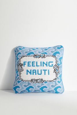 a blue pillow with the words feeling nautt printed on it, against a white wall