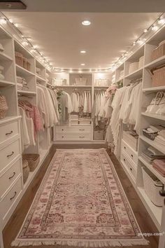 a walk in closet filled with lots of clothes and rugs on top of wooden flooring