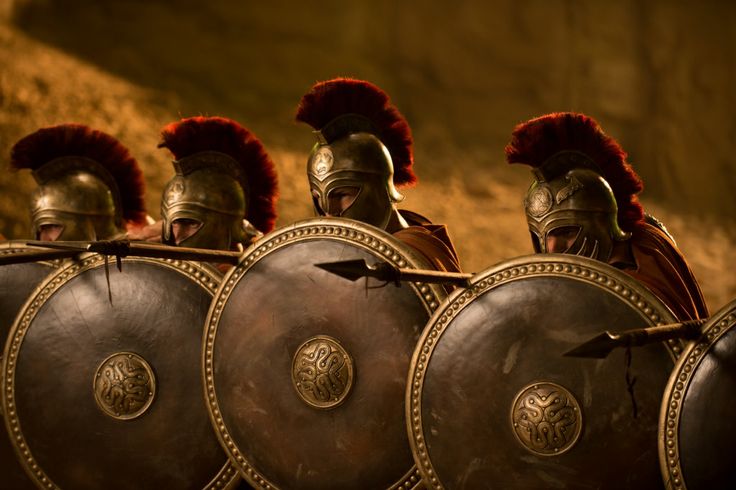 three men in roman armor with red hair and beards on their heads, standing next to each other