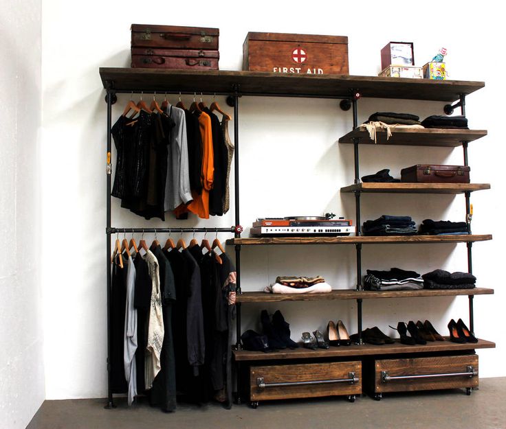 an organized closet with clothes, shoes and suitcases hanging on the wall next to it