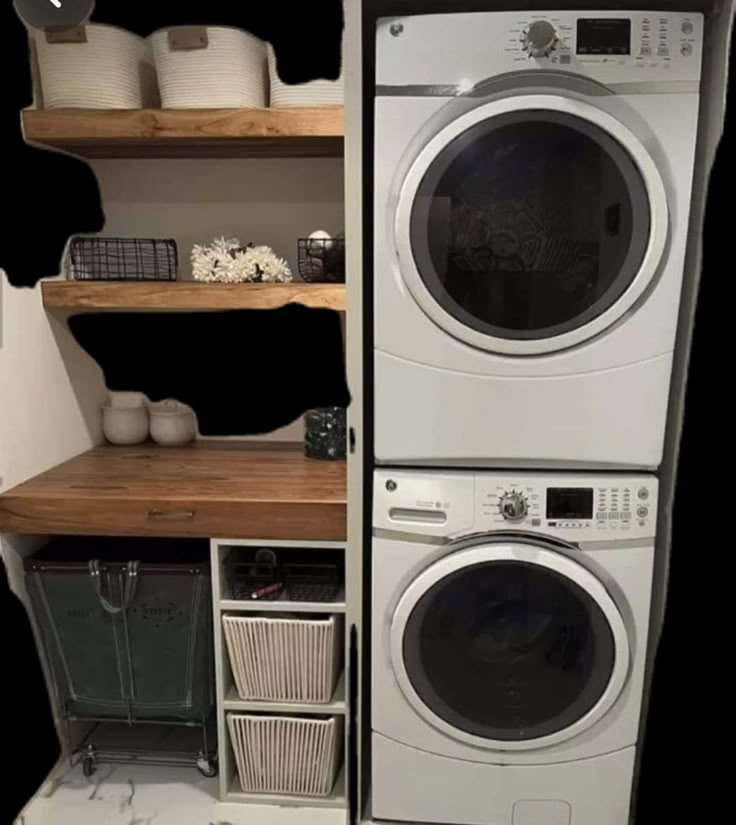 two washers and dryer stacked on top of each other in a laundry room