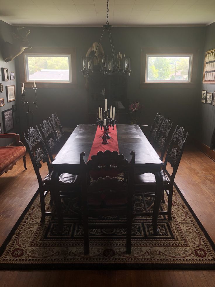 a dining room table with chairs and a rug on the floor in front of it