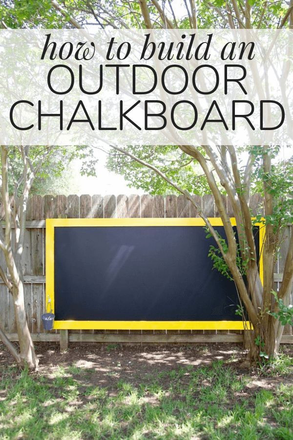 an outdoor chalkboard in the middle of a yard with text overlay that reads how to build an outdoor chalkboard