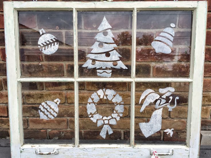 an old window decorated with christmas decorations on the outside, and painted in white paint