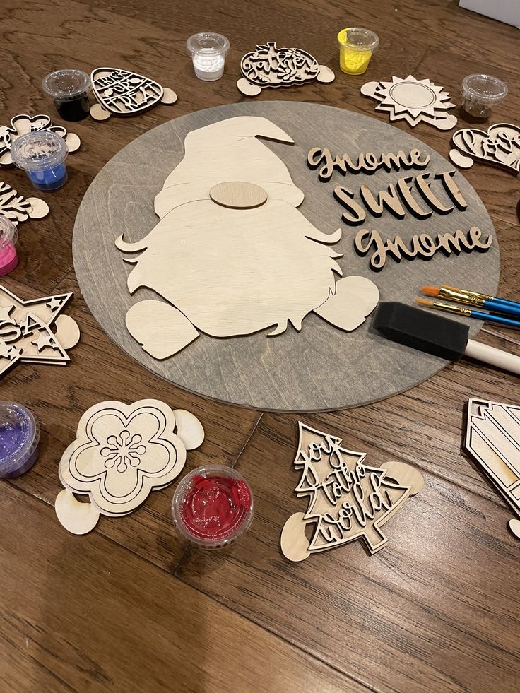 some cutouts are laying on the table with paint and markers in front of them