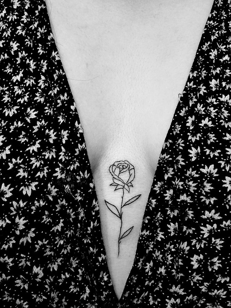 a woman's chest with a rose tattoo on the left side of her stomach