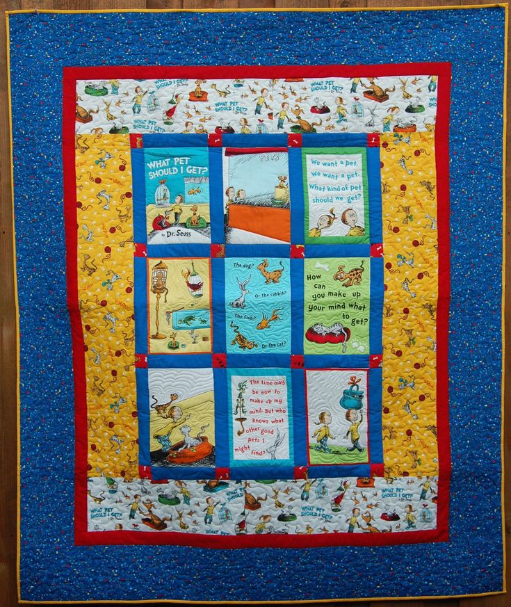 a blue and yellow quilted wall hanging with dr seuss's books on it