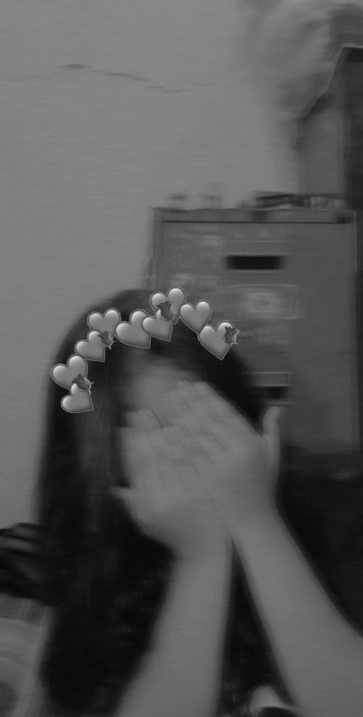 black and white photograph of a woman holding something in front of her face