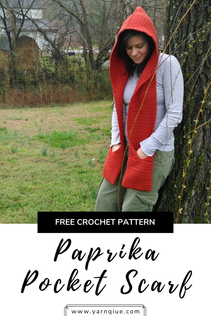 a woman standing next to a tree wearing a red crochet hooded jacket with text overlay that says free crochet pattern papika pocket scarf