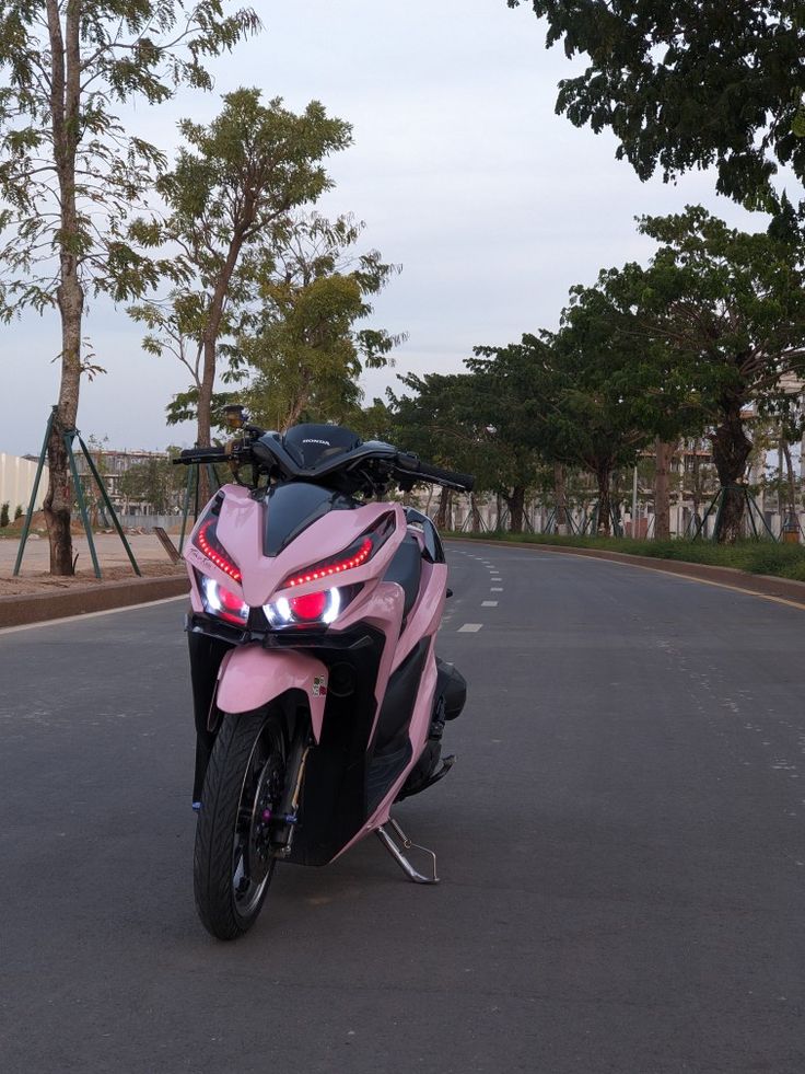 a pink motorcycle is parked on the street