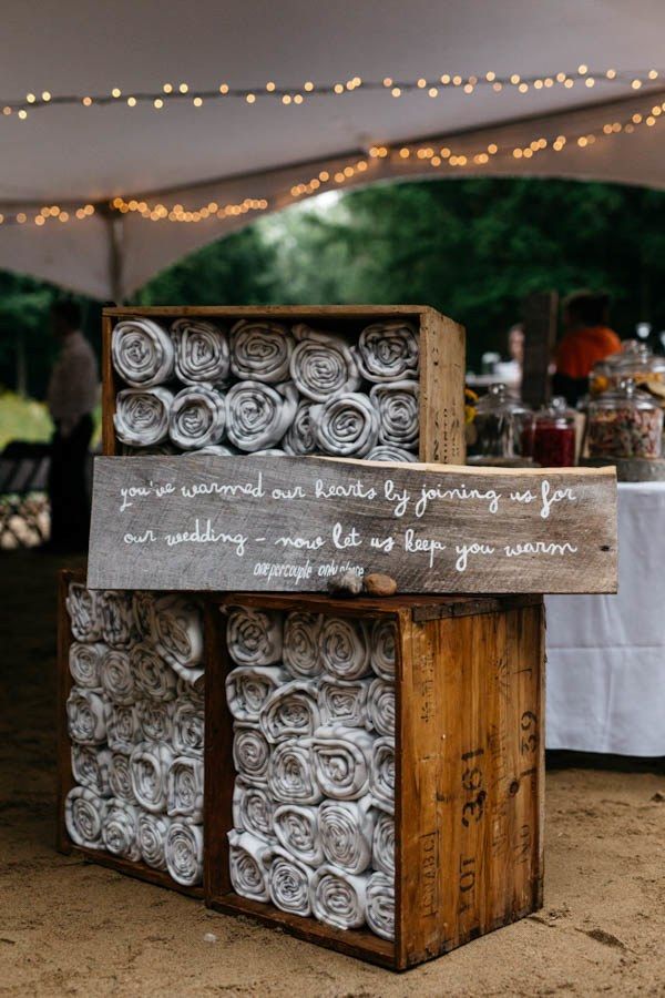 a wooden box that has rolled up towels in it and some lights on the side