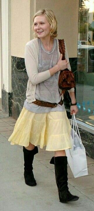 a woman is walking down the street with her hand in her pocket and holding shopping bags