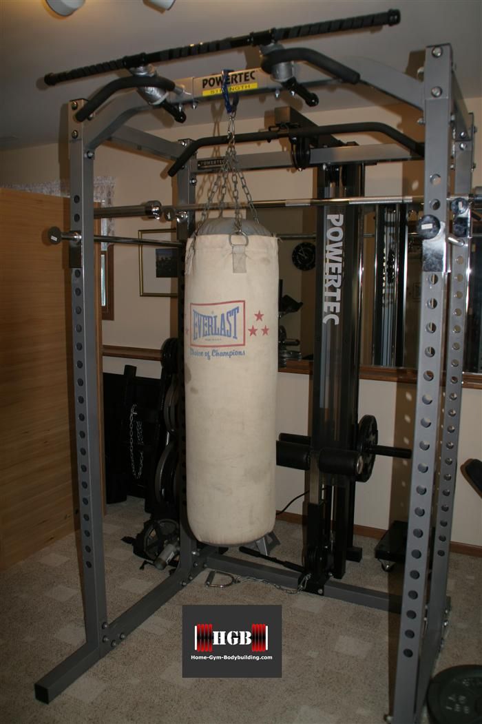 a white punching bag hanging from the ceiling in a home gym with equipment on the floor