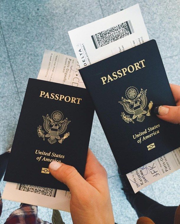 two people are holding up their passport cards