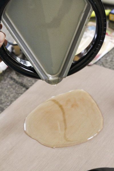 a person holding a magnifying glass over a piece of food on a table