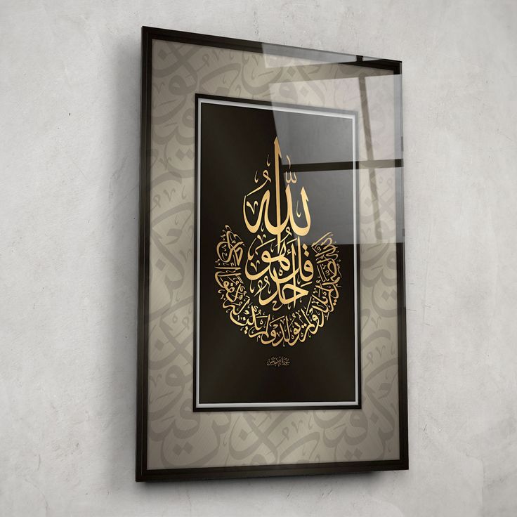 an arabic calligraphy is displayed in a framed glass frame on the wall above it