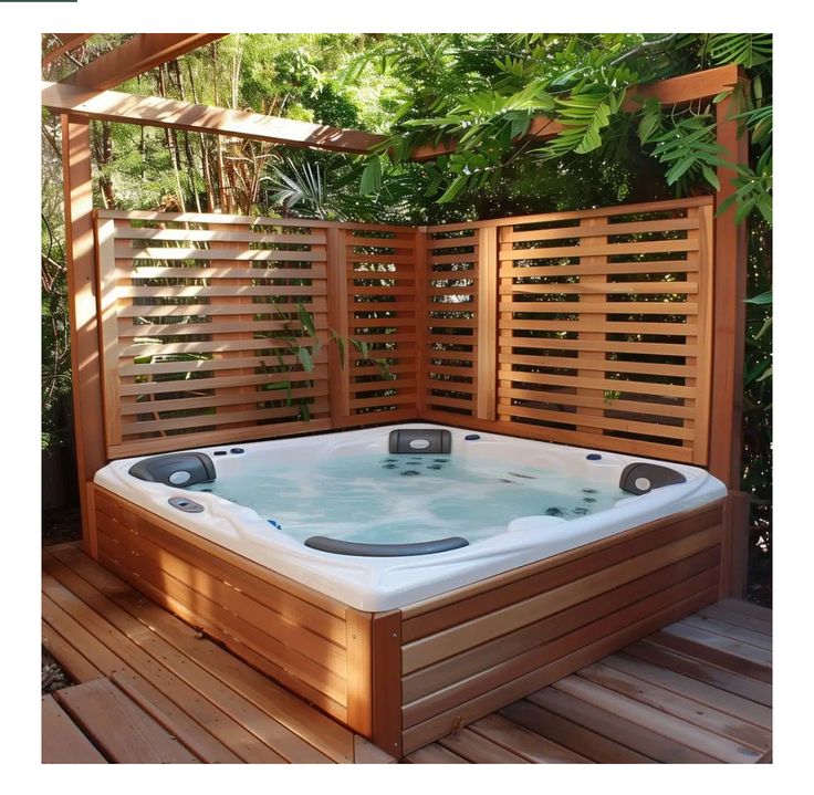 a hot tub sitting on top of a wooden deck next to a privacy fence and trees