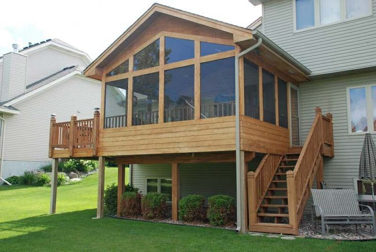 a large house with a deck and stairs leading up to the upper level balcony area