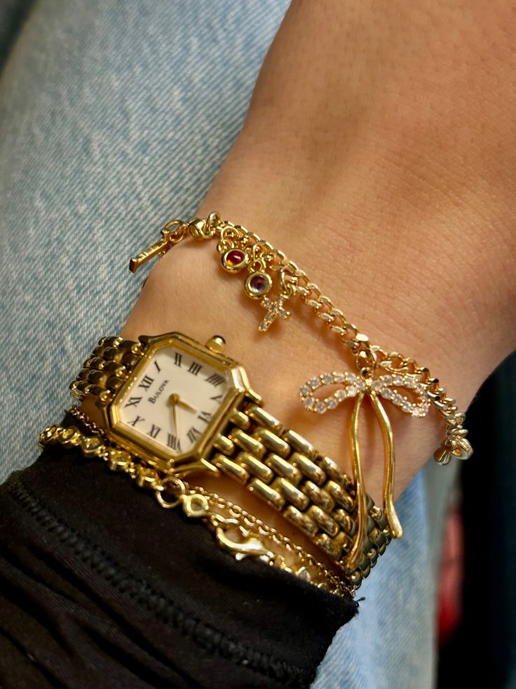 Charm bracelet Bow charm Gold watch Gold charms Gold Watch Jewelry, Gold Jewelry Stacking, Golden Bracelet Stack, Shop The Deli Jewelry, Chunky Gold Bracelet Stack, Gold Jewelry Stack Bracelet, Cute Gold Watch, Jewelry Stack Gold, Gold Watch And Bracelet Stack