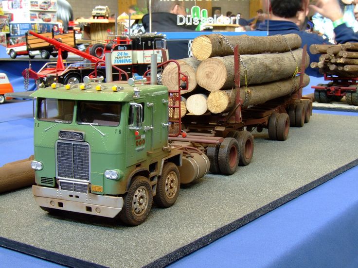 a green semi truck with logs on the back