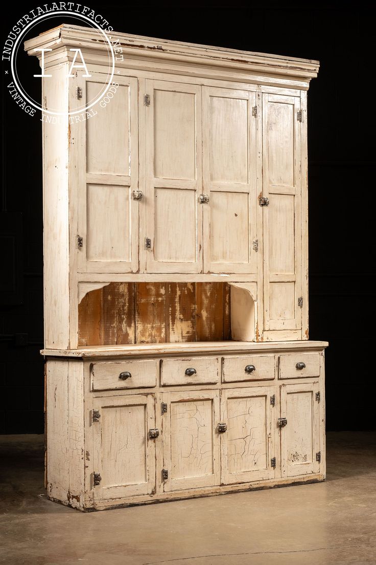 an old white cabinet with drawers and cupboards on it's sides, against a black background