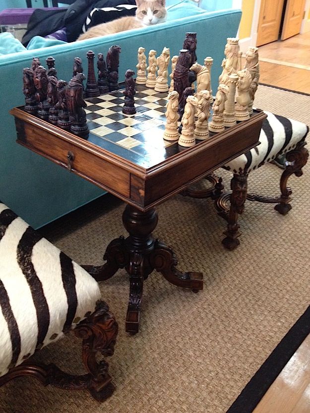 a chess set is sitting on the floor in front of a couch