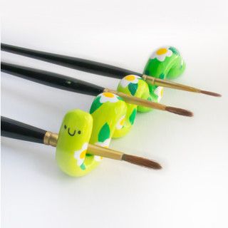 four chopsticks with green and white designs on them sitting next to each other