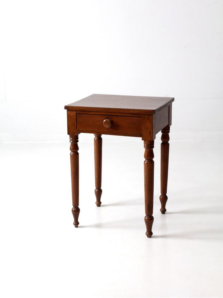 a small wooden table sitting on top of a white floor