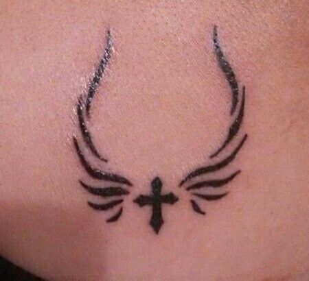 a cross and wings tattoo on the back of a woman's neck