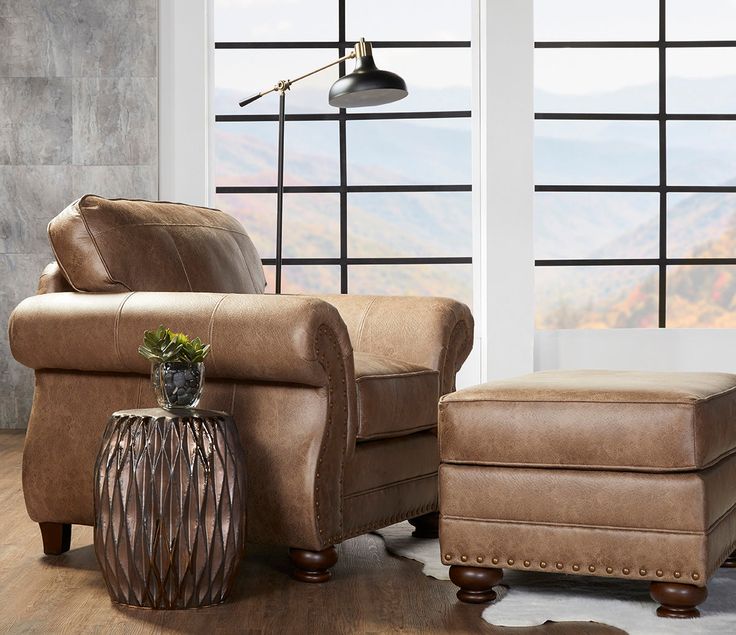 a living room scene with focus on the chair and footstool