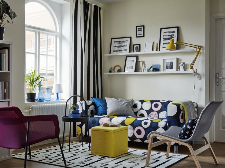 a living room filled with colorful furniture and decor on top of a hard wood floor