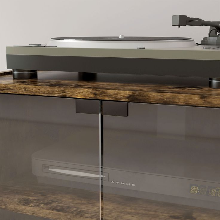 a record player sitting on top of a wooden table next to a glass cabinet with drawers