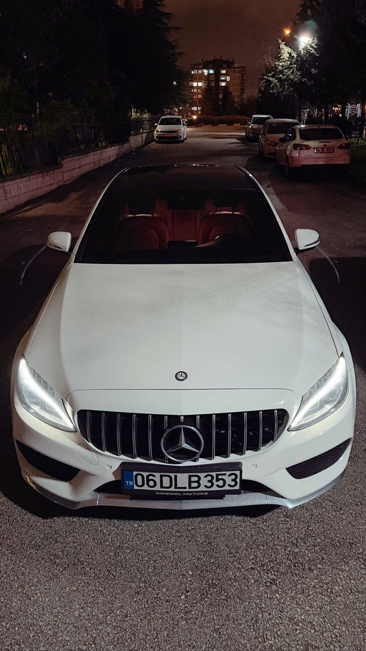 a white car parked on the street at night