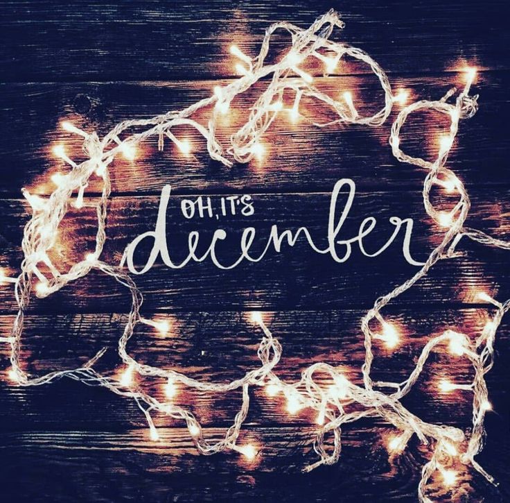 a wooden background with lights and the words, oh it's december