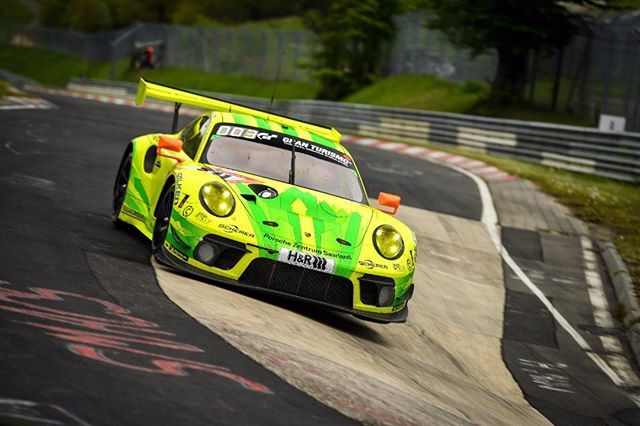 a yellow and green race car driving on a track