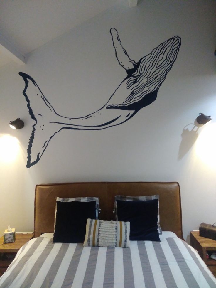 a bedroom with a large bed and wall decal