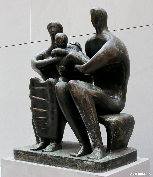 a bronze statue of two people sitting on a bench with their arms around each other