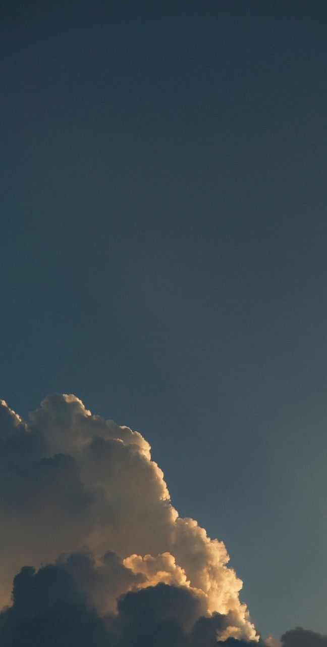 the plane is flying high in the sky with clouds behind it and sun coming through