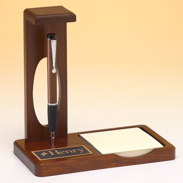 a pen and note pad on a wooden stand