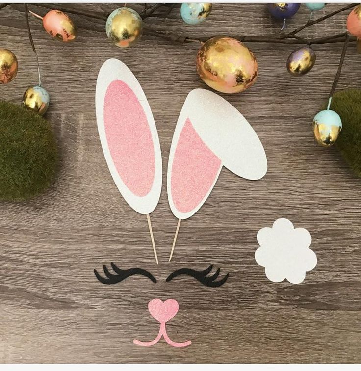 a wooden table topped with easter decorations and bunny ears