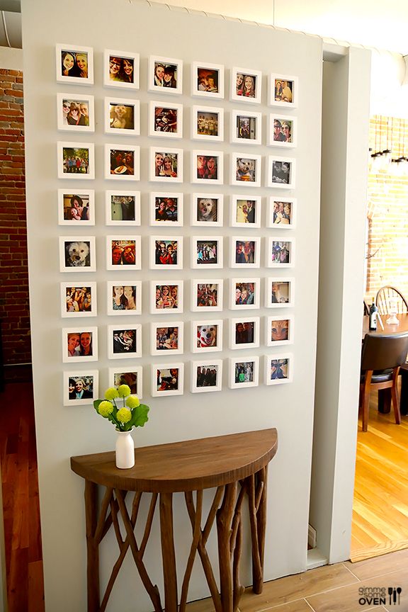 a room with pictures on the wall and a small table in front of it,