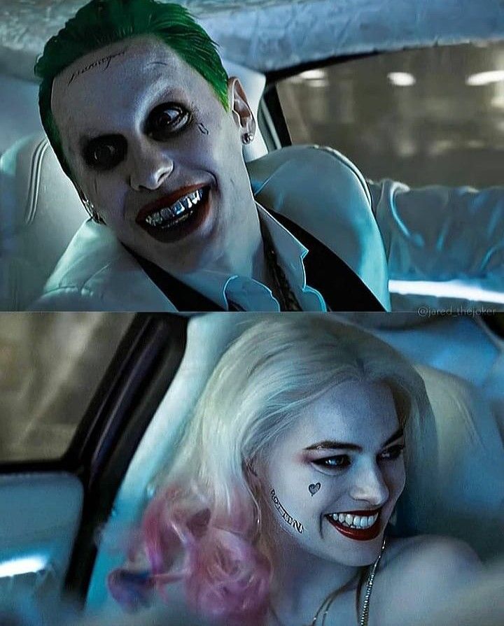 the joker is driving in his car with pink hair