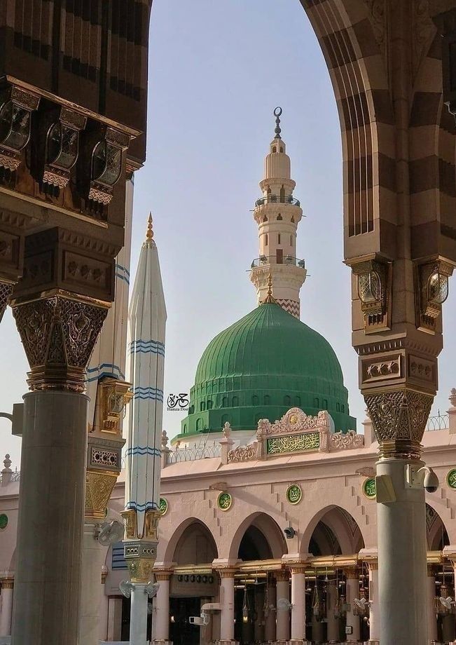 an ornate building with a green dome and minalis in the foreground, surrounded by other buildings